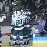 Featured Image Caption:Iowa Wild forward Brett Bulmer is mobbed by teamamtes Brian Connelly, Chad Rau and Jason Zucker after Bulmer scored the Wild's first-ever goal, Saturday, Oct. 12, 2013, in Des Moines, Iowa. The 1-0 win was the AHL franchise's first in its new Iowa home. (Iowa Wild Photo by Reese Strickland)