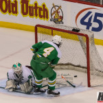 Featured Image: Edina's Anthony Walsh slips the puck through Hill Murray goatender, John Dugas to make it 4-1 for the Hornets. (Photo by Jeff Wegge)